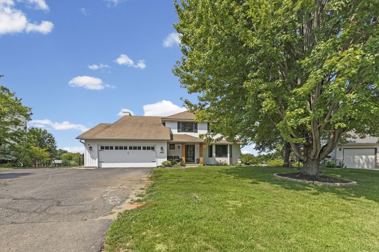 Front exterior of house with driveway and mature trees