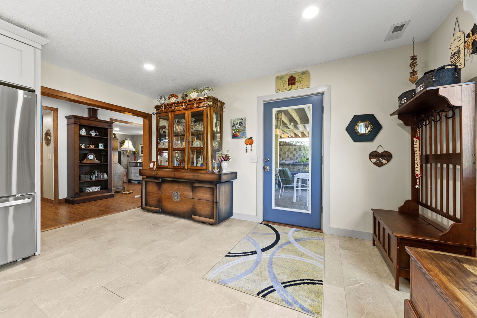 Entry foyer with blue front door and display cabinet