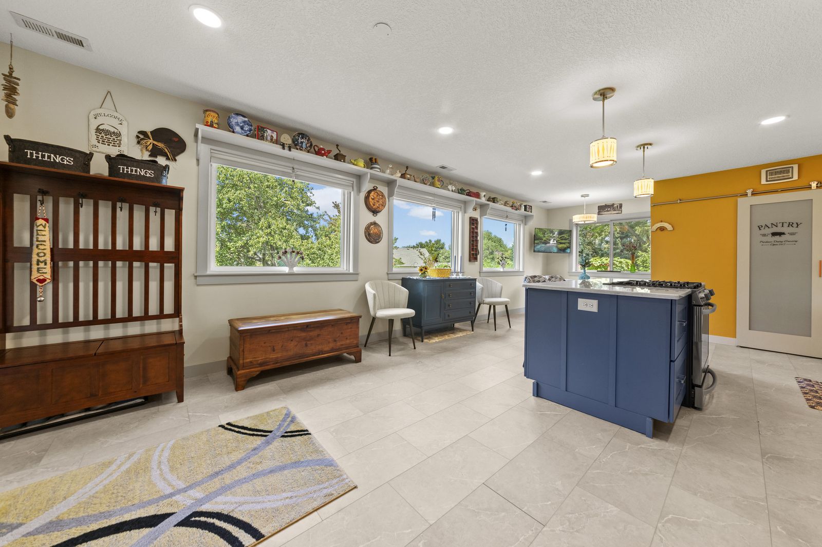 Kitchen with blue island and open view to dining and living areas