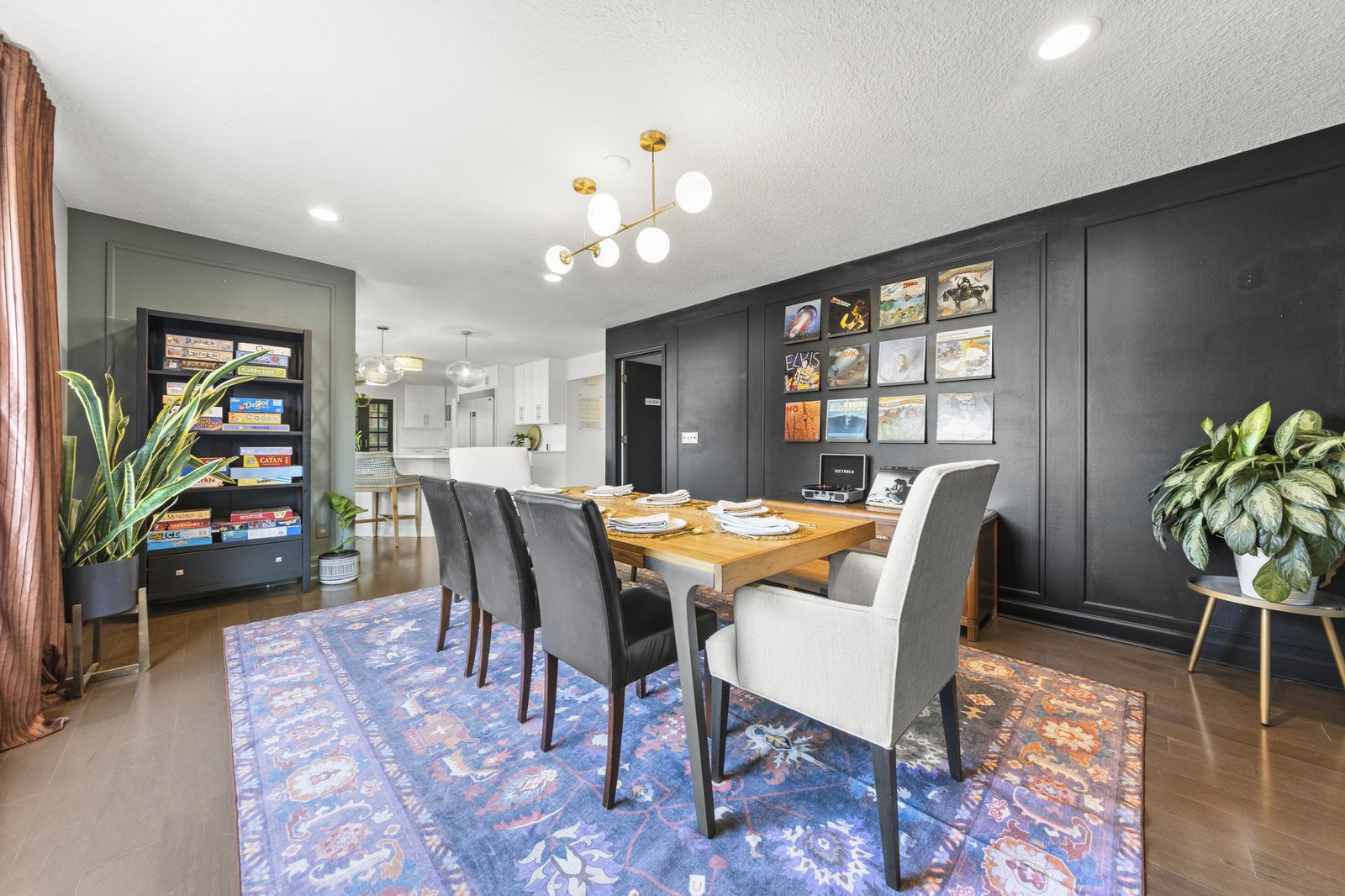 Dining area with bookshelf and dark accent wall, alternate view