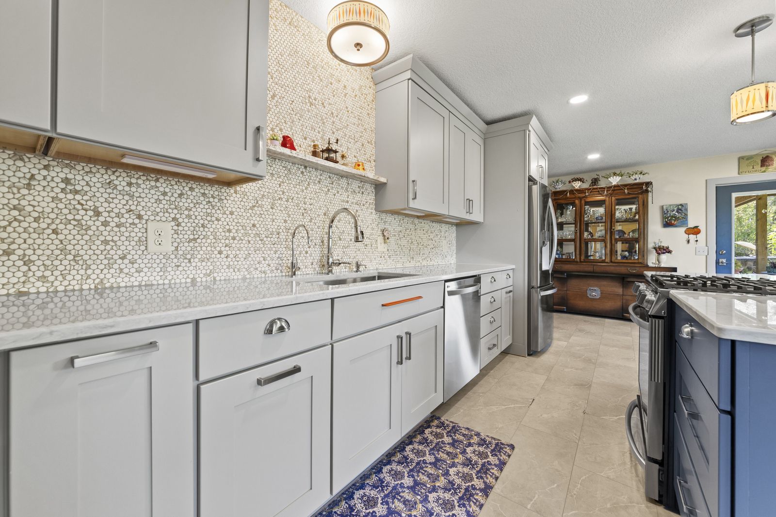 Kitchen sink area with tile backsplash