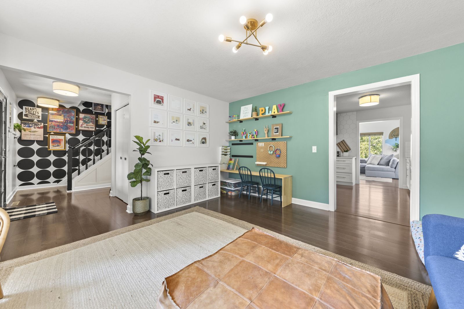 Upstairs bonus room with playroom shelving and staircase view