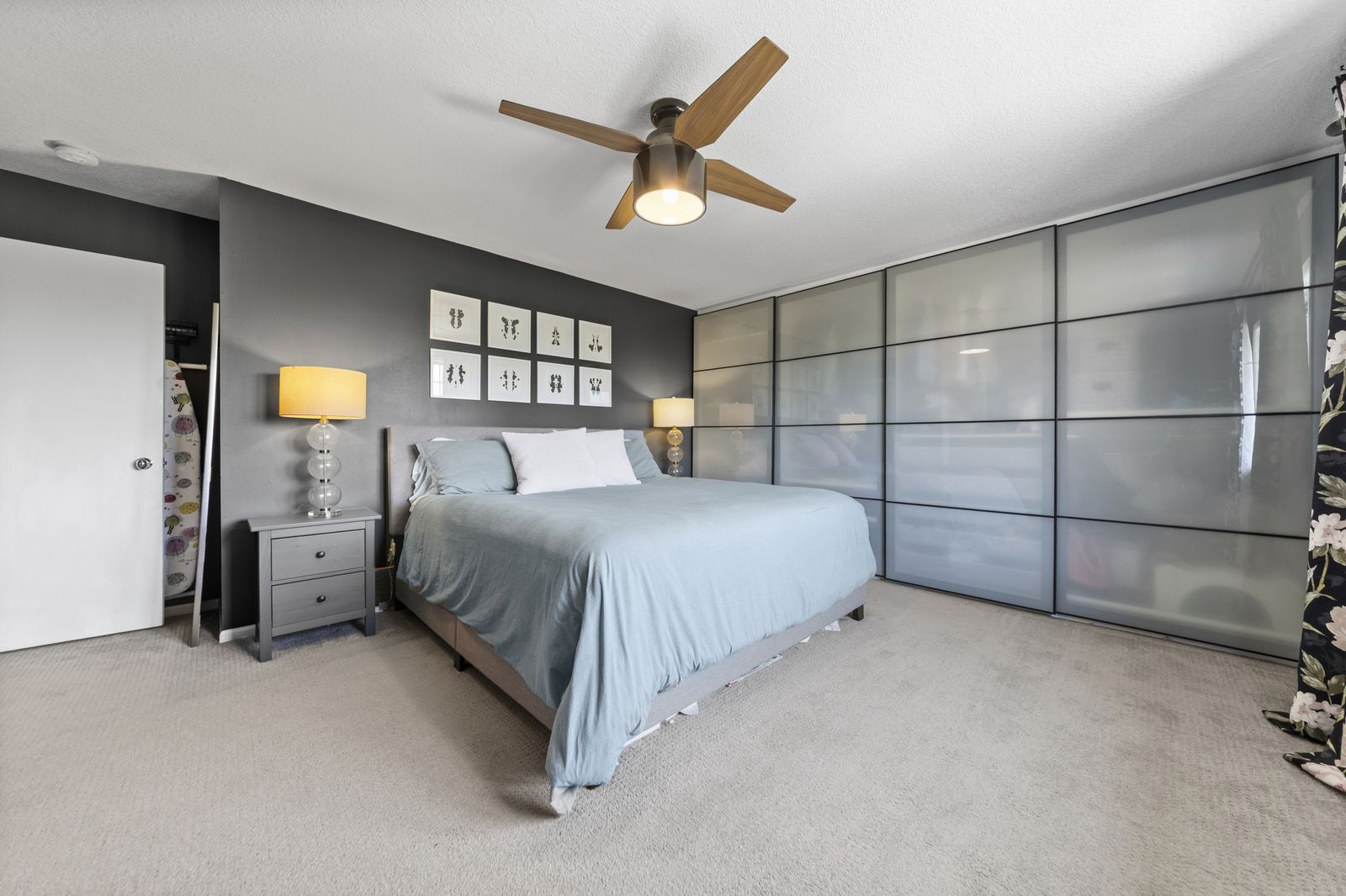 Bedroom with frosted glass closet doors and blue bedding