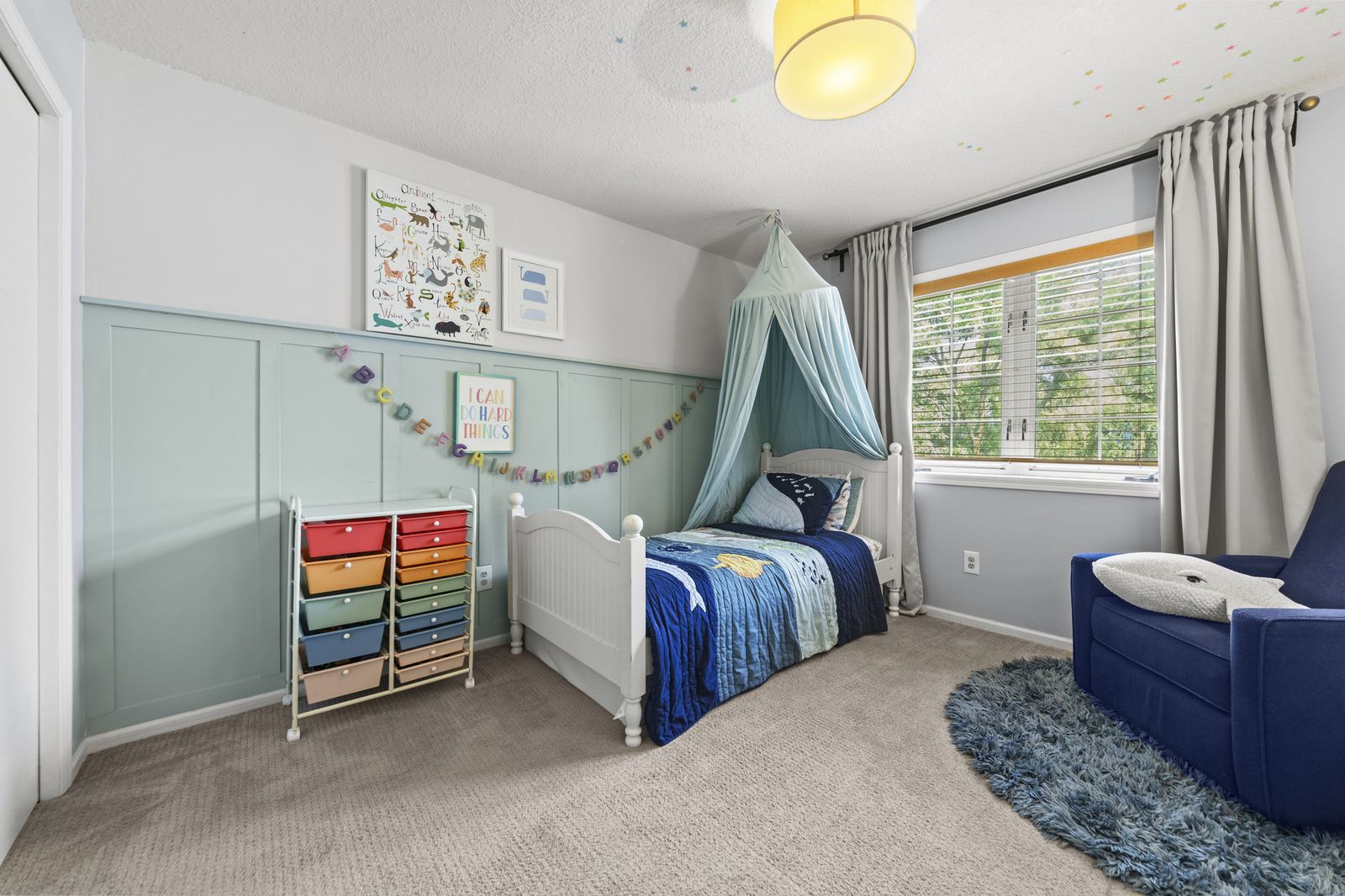 Child's bedroom with canopy bed and window seat