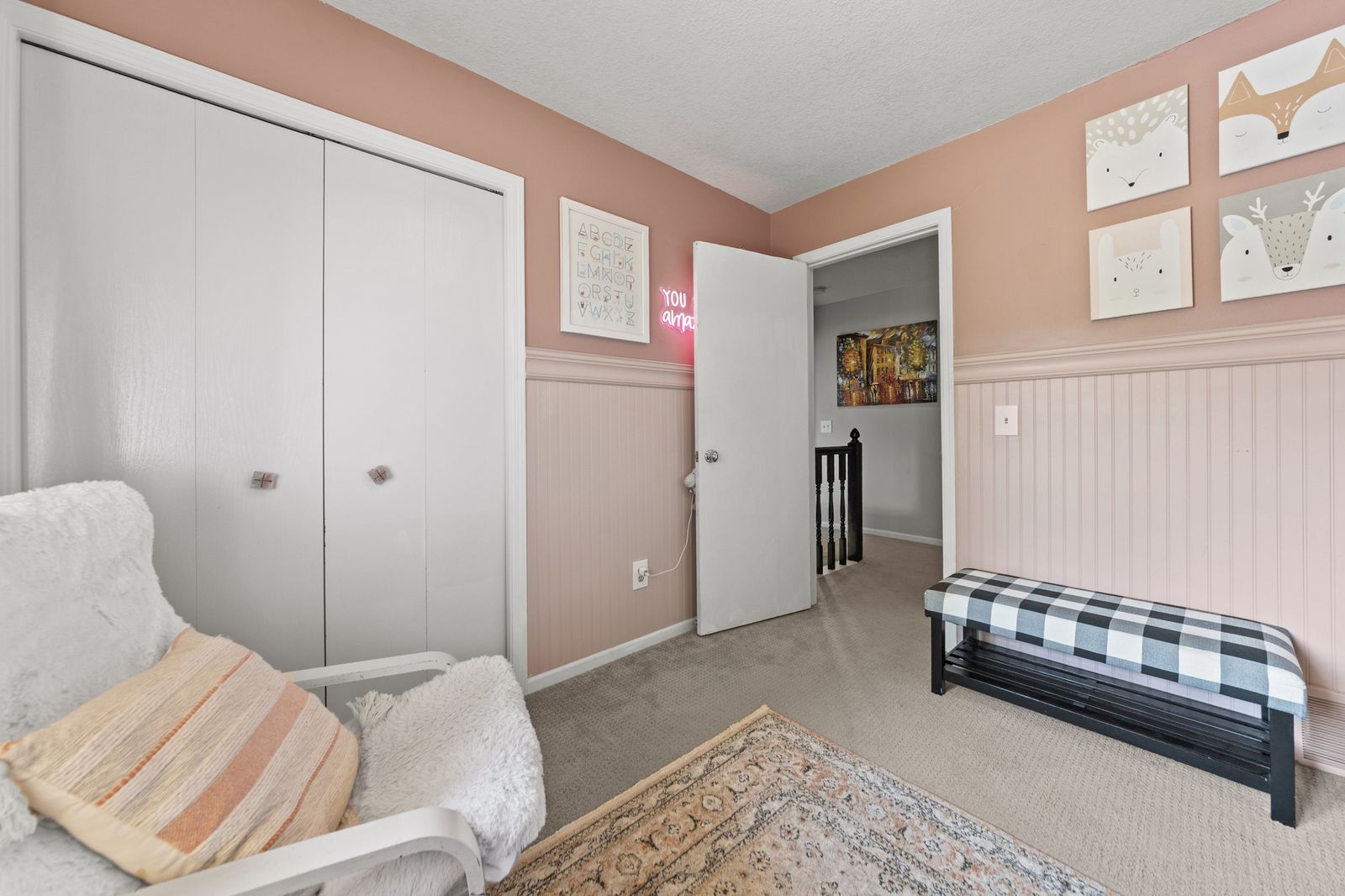 Bedroom with pink accent wall and closets