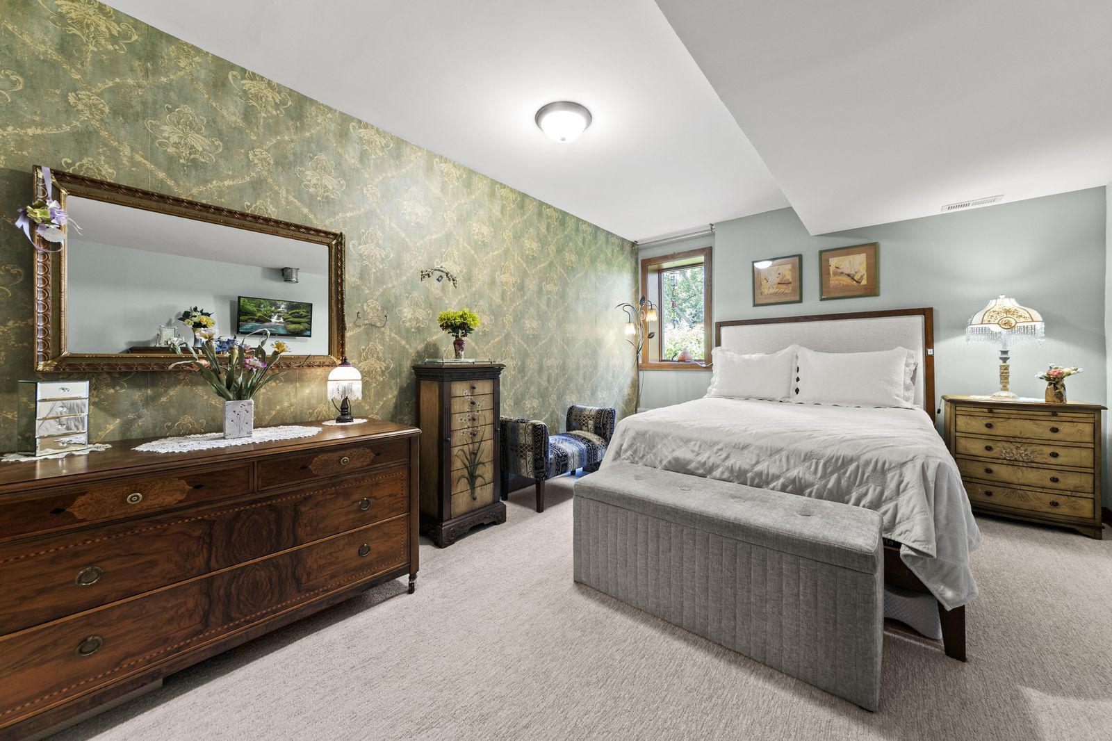 Primary bedroom with vaulted ceiling and dresser