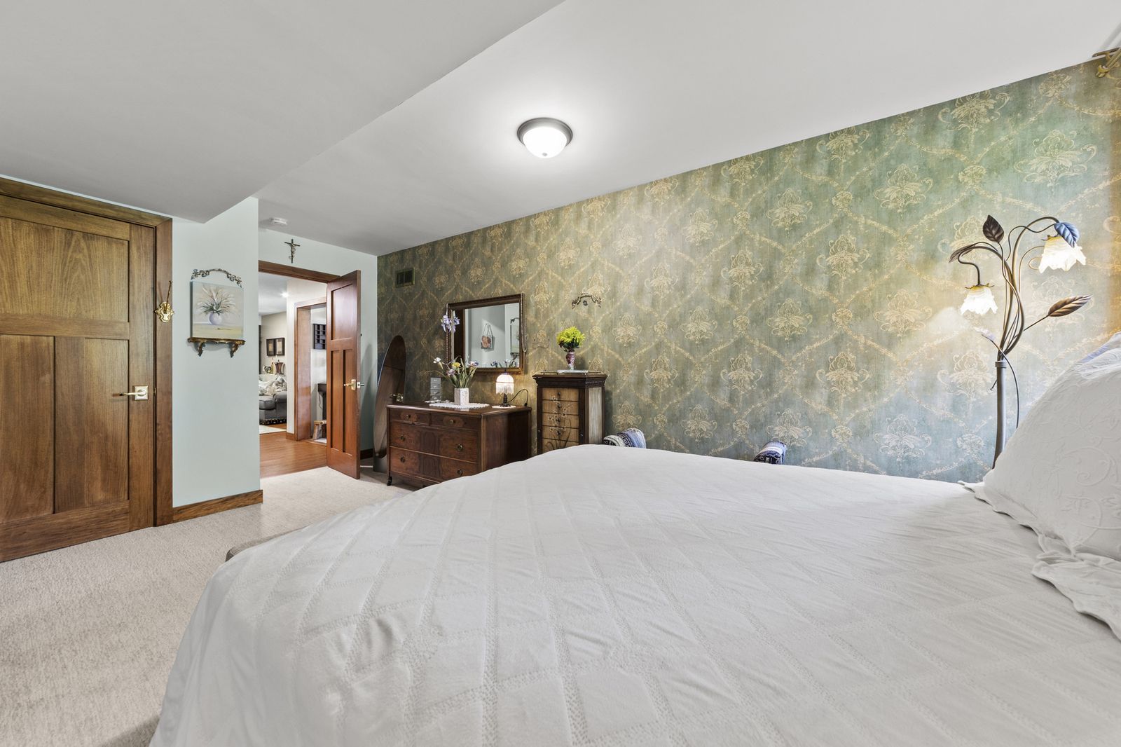 Bedroom with green wallpaper and view to hallway