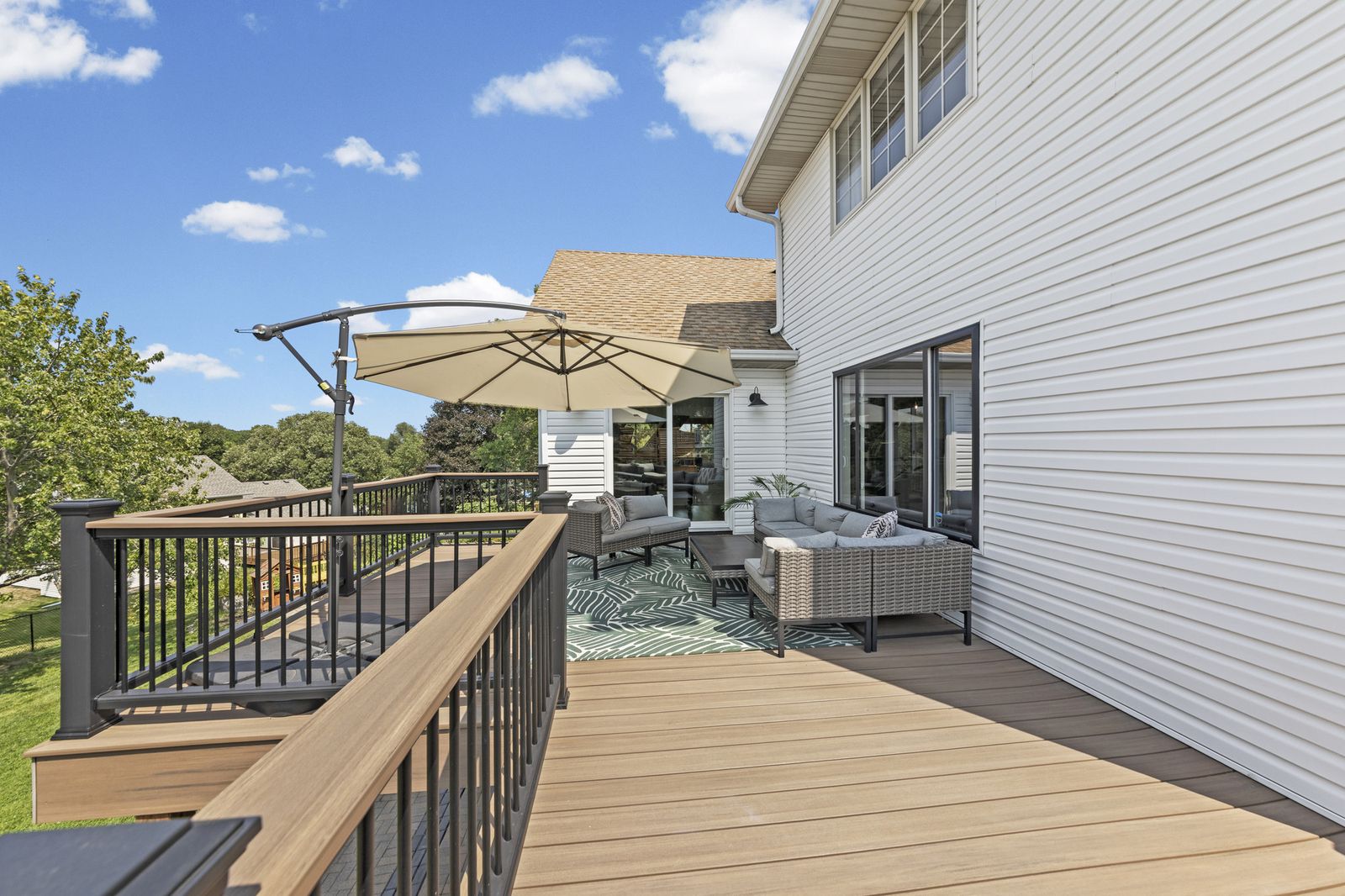 Rear exterior deck with lounge furniture and umbrella