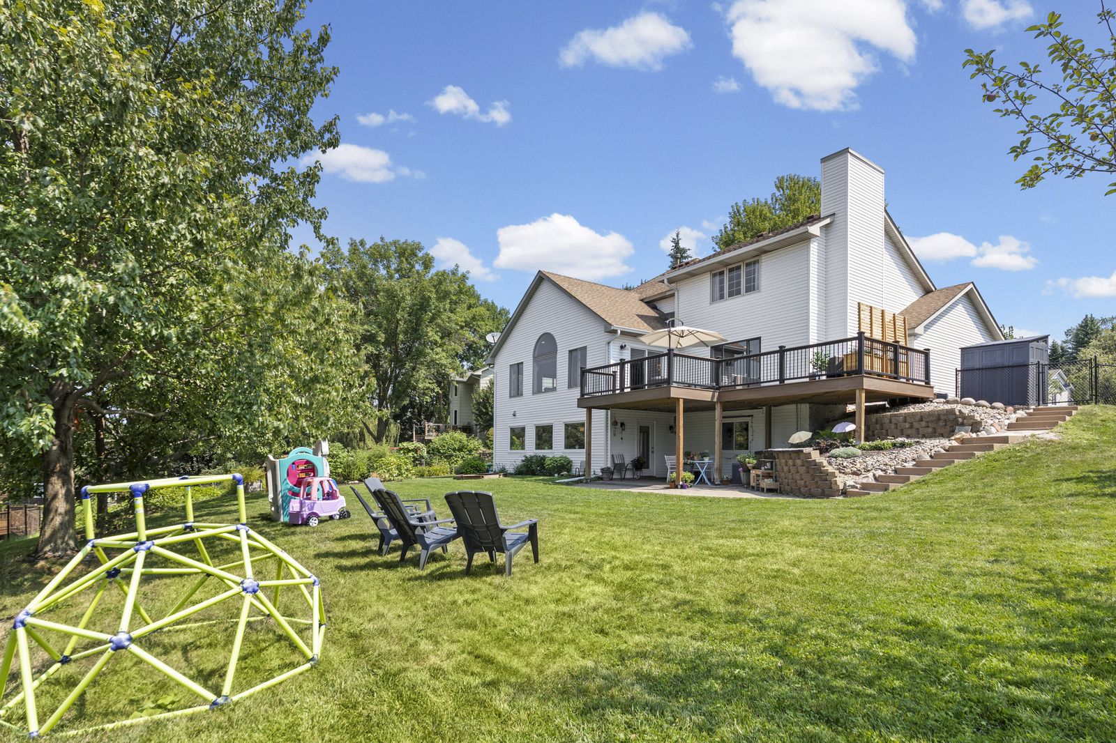 Rear exterior view of house with deck and yard play equipment