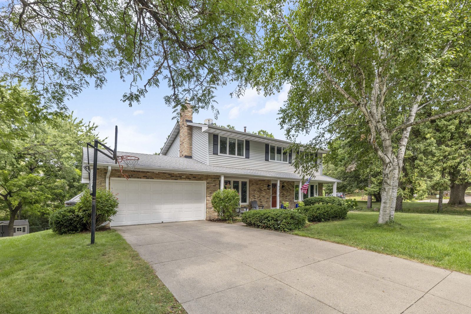 Front exterior of house with driveway and basketball hoop