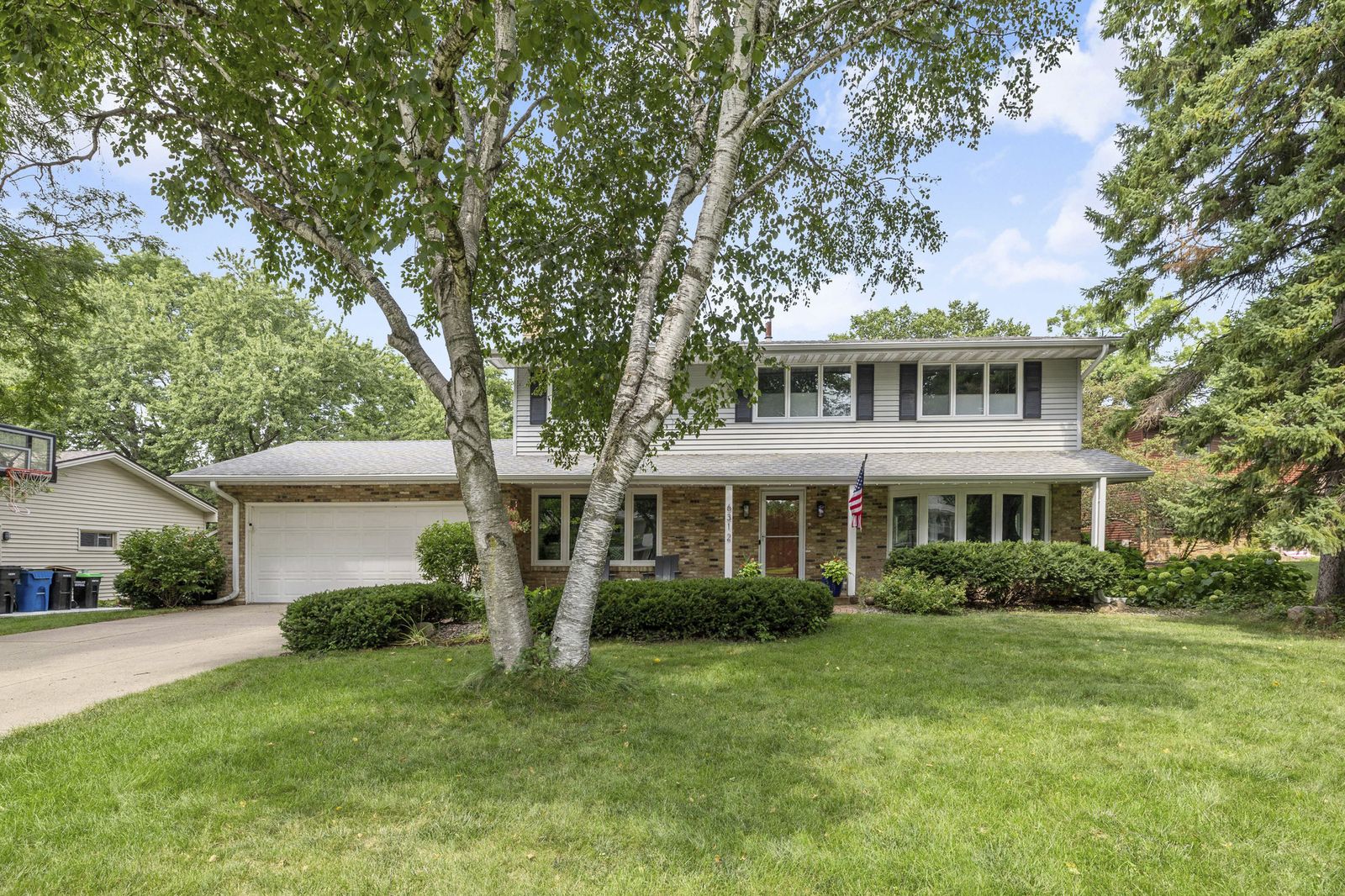 Front exterior of house with large tree and lawn