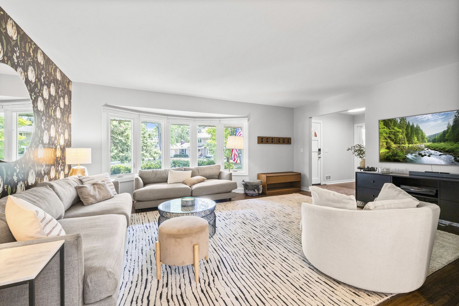 Living room with bay window, virtually staged with sofas and rug