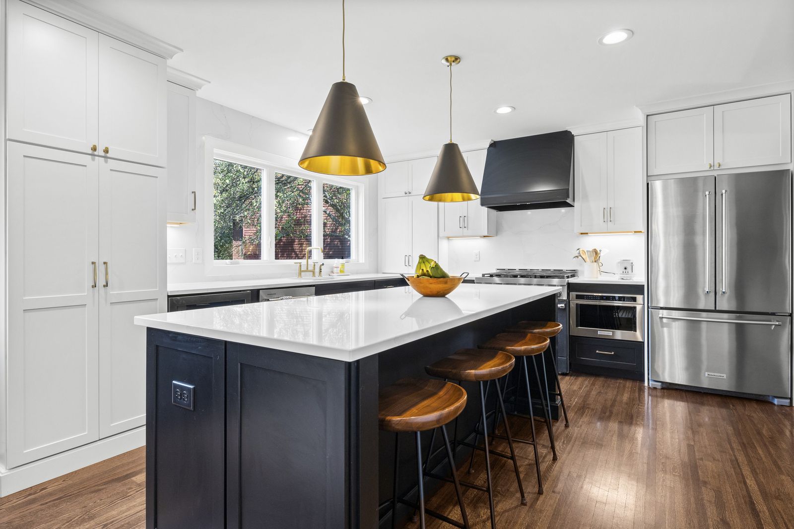 Kitchen with stainless steel refrigerator and bar seating