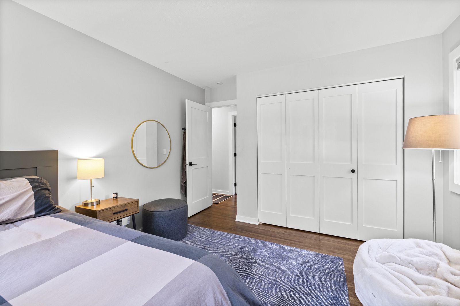 Bedroom with closet and round mirror