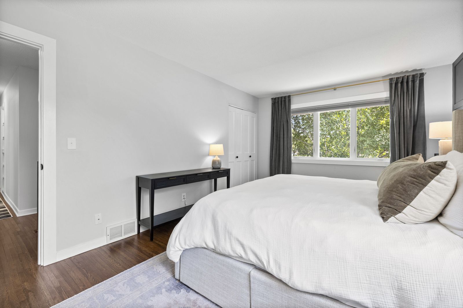 Bedroom with large window and nightstand
