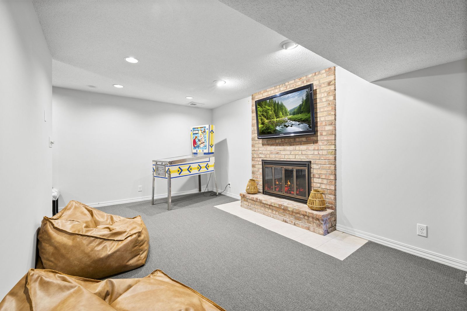 Lower level room with brick fireplace and bean bag chairs