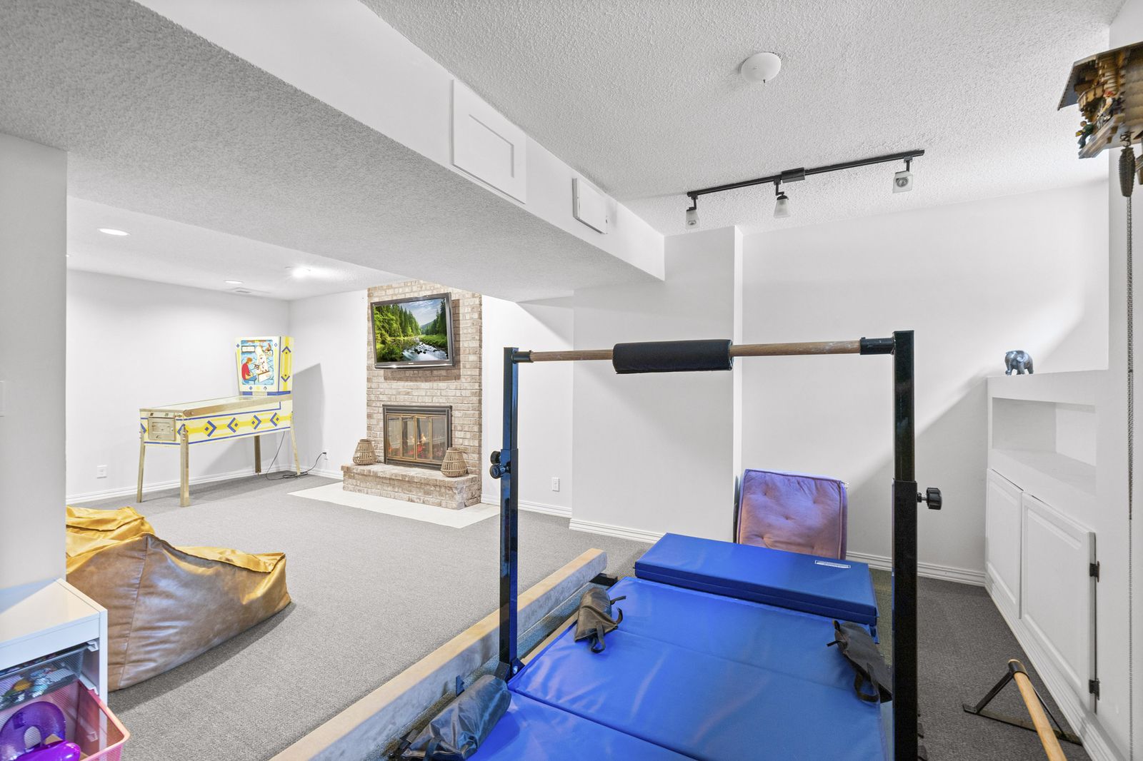 Lower level exercise area with pull-up bar and fireplace
