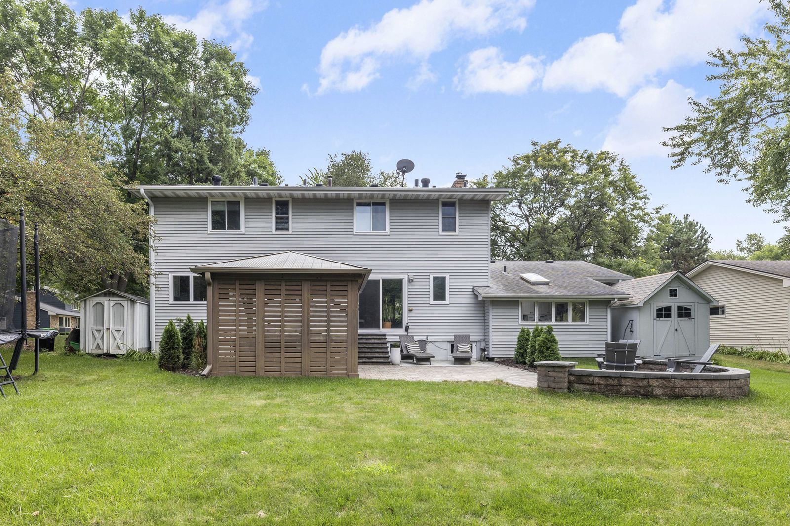 Rear exterior of house with backyard patio and shed