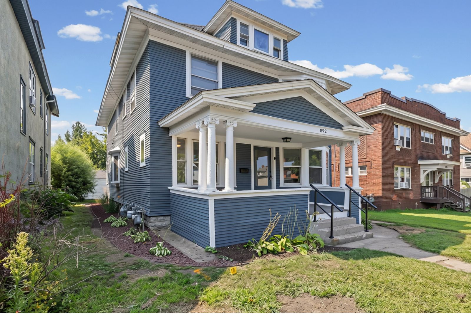 Front exterior of blue house with columned entry porch