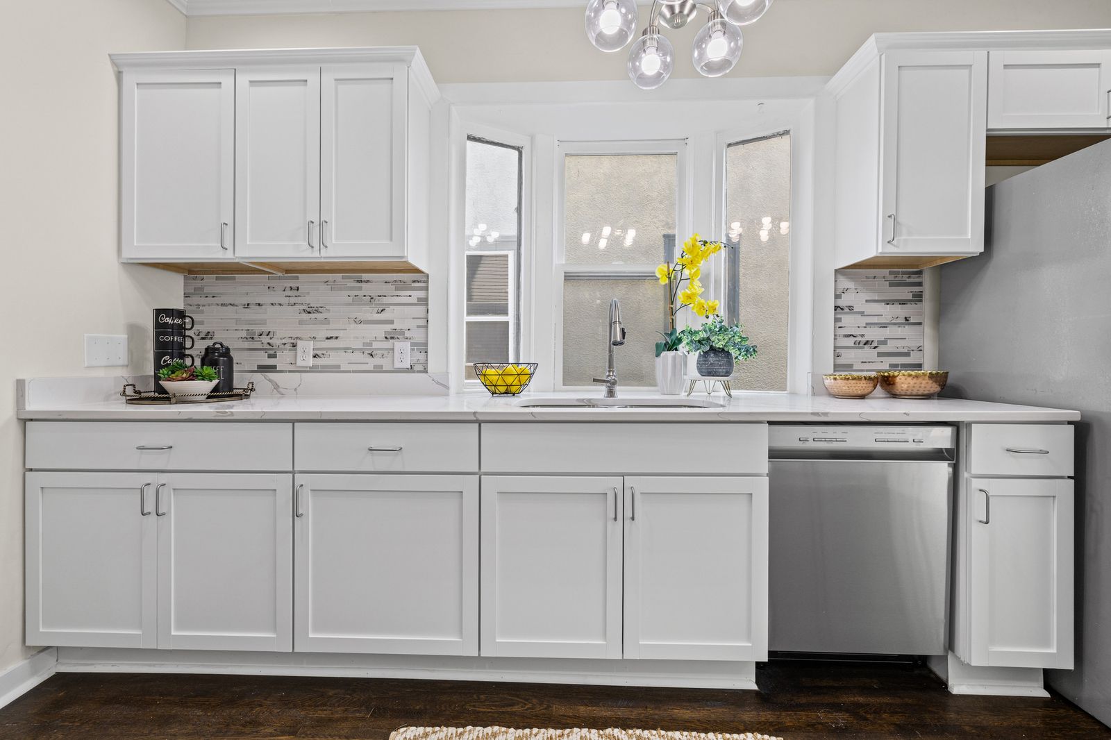 Kitchen with tile backsplash and white cabinets