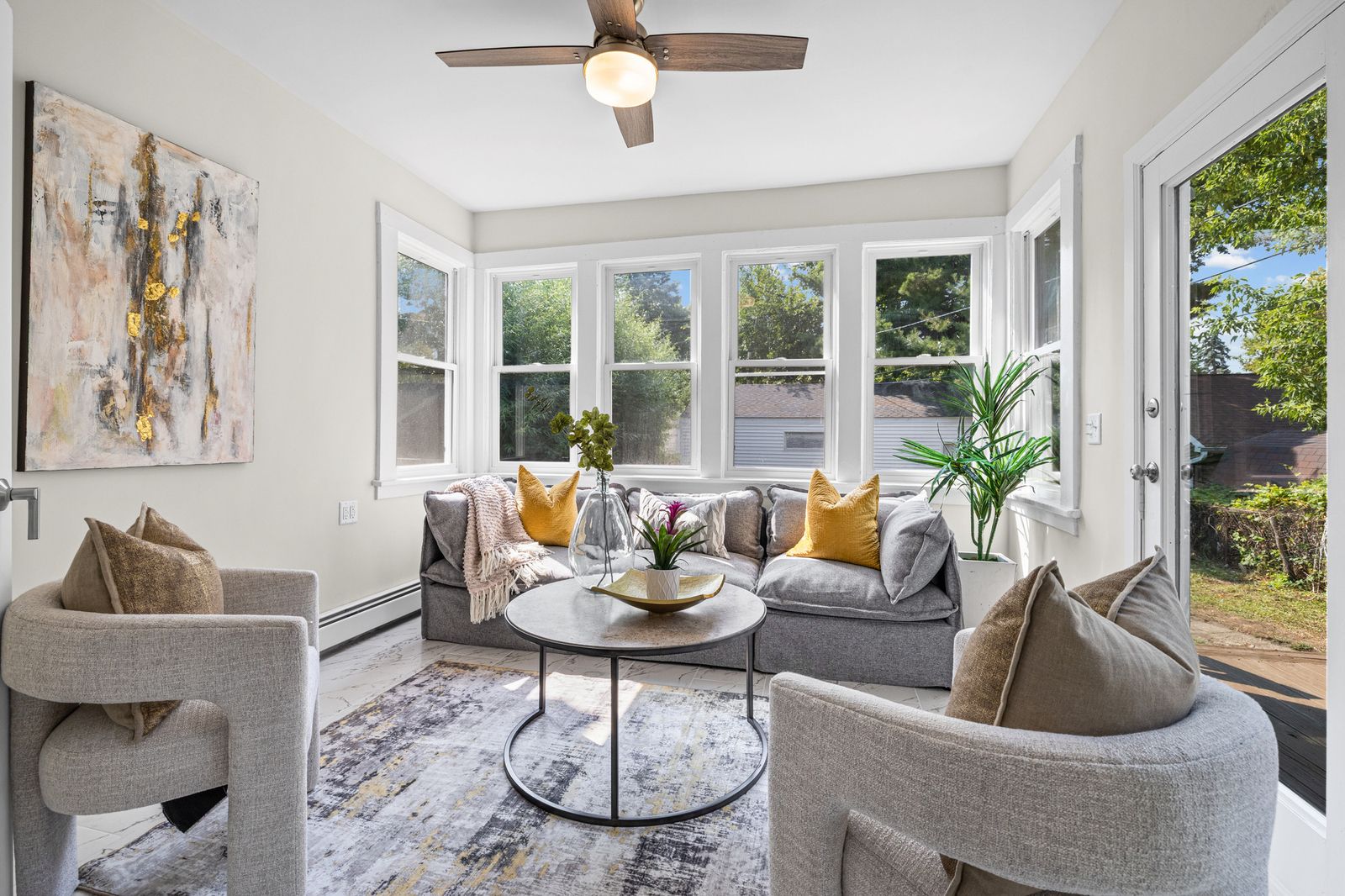Sunroom living area, virtually staged with gray sofas
