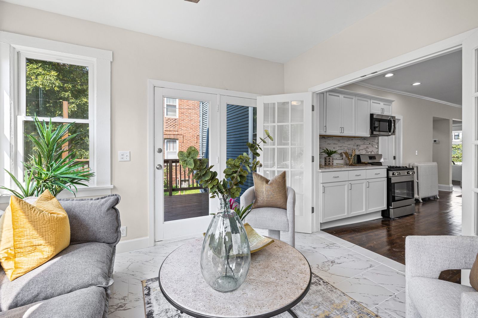 Living area with view to kitchen, virtually staged with round table