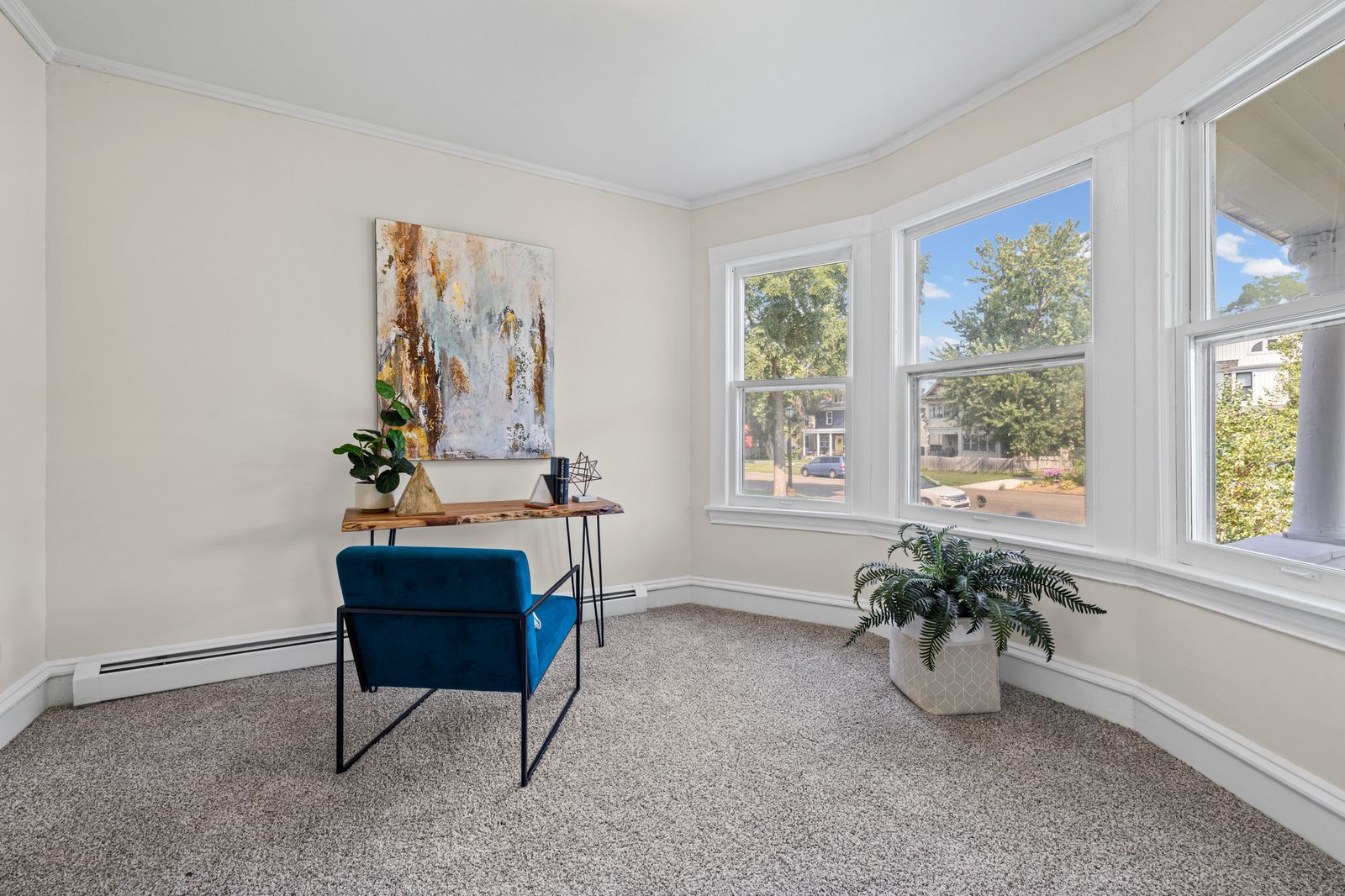 Upstairs sitting room with bay window, virtually staged with blue chair