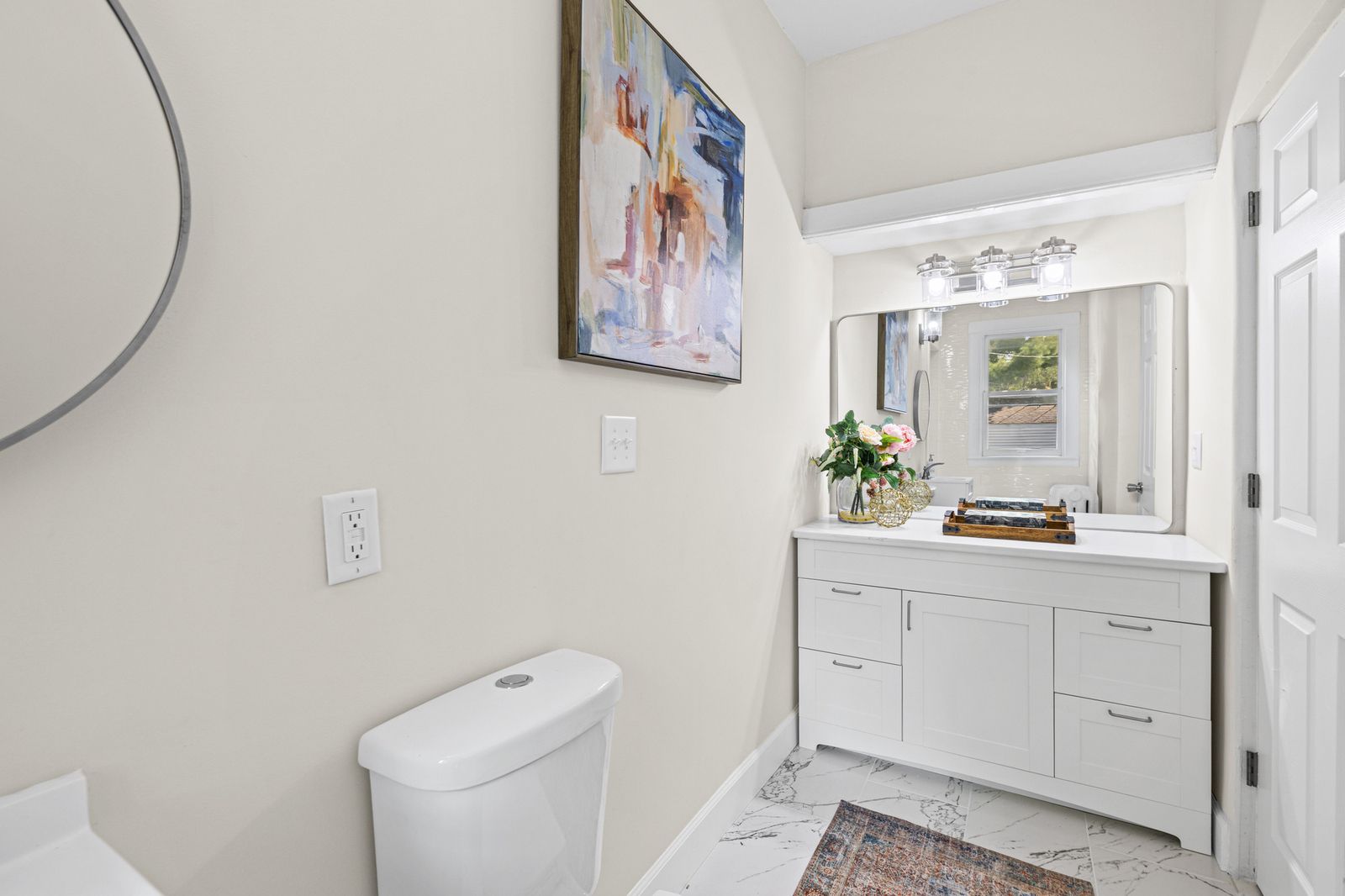 Upstairs bathroom with white vanity and artwork